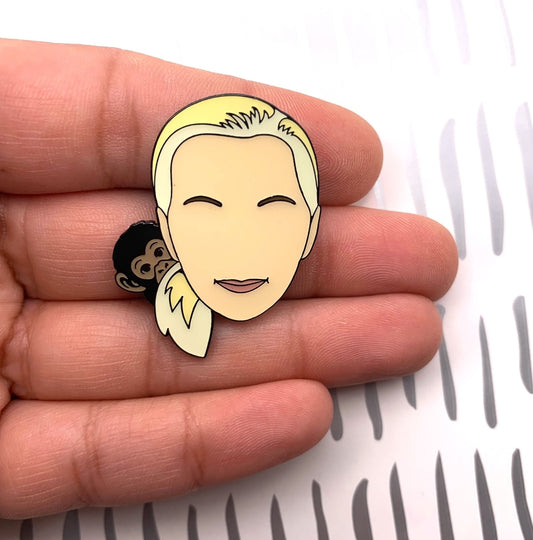 Pin of Dr Jane Goodall held between fingers on a white background
